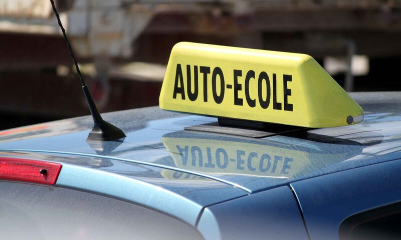 Panneau auto-école sur un véhicule équipé pour la formation à la conduite